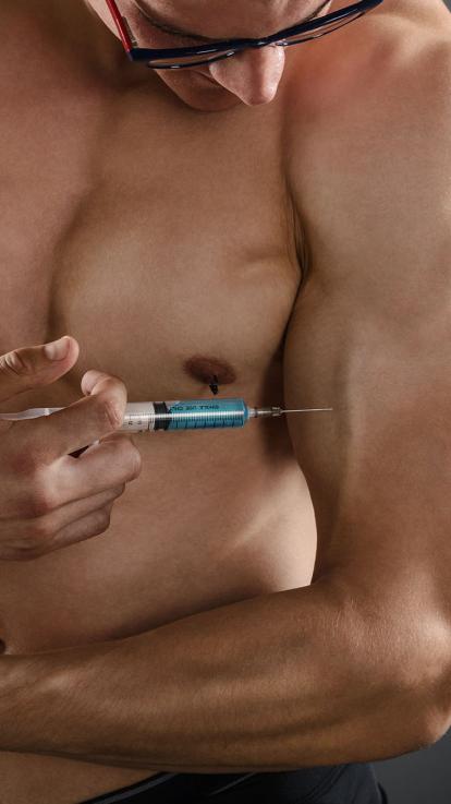 Man met gespierd lichaam heeft een testosteronspuit vast