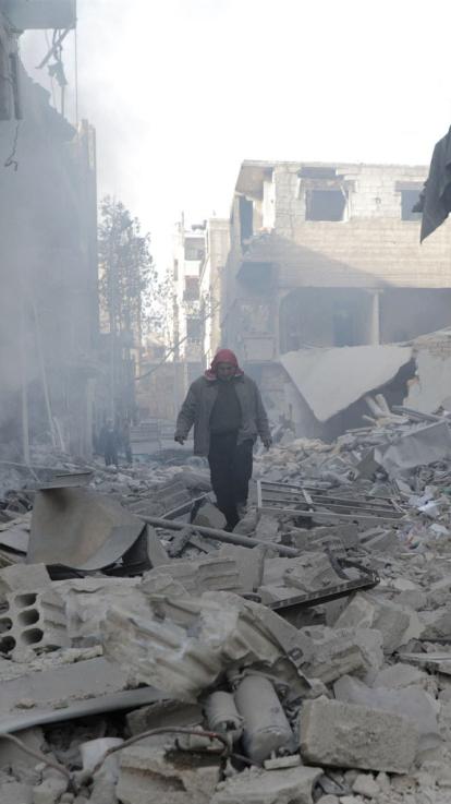 een man loopt in het puin na een bombardement