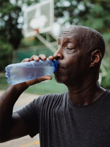 Man neemt slok uit een waterflesje