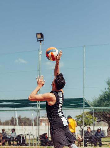 Man slaat volleybal op strand ondergrond