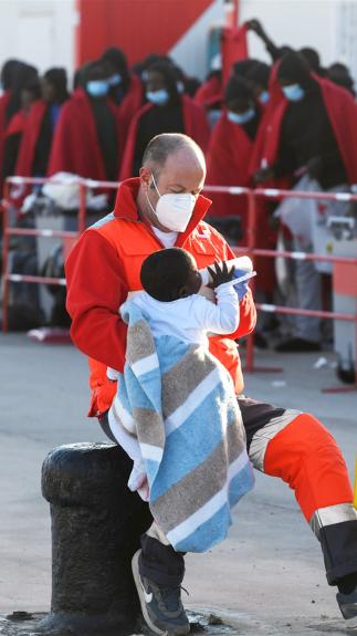 een Rode Kruis-medewerker is een baby aan het voeden