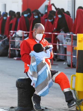 een Rode Kruis-medewerker is een baby aan het voeden