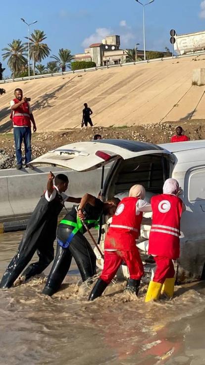 medewerkers van de Rode Halve Maan helpen bij een overstroming in Libië