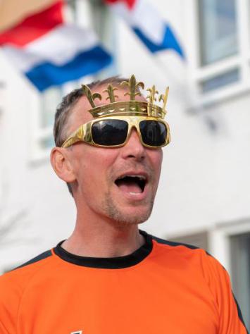 iemand zingt het Wilhelmus in oranje-outfit