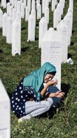 een vrouw in tranen bij een graf van de genocide in Srebrenica