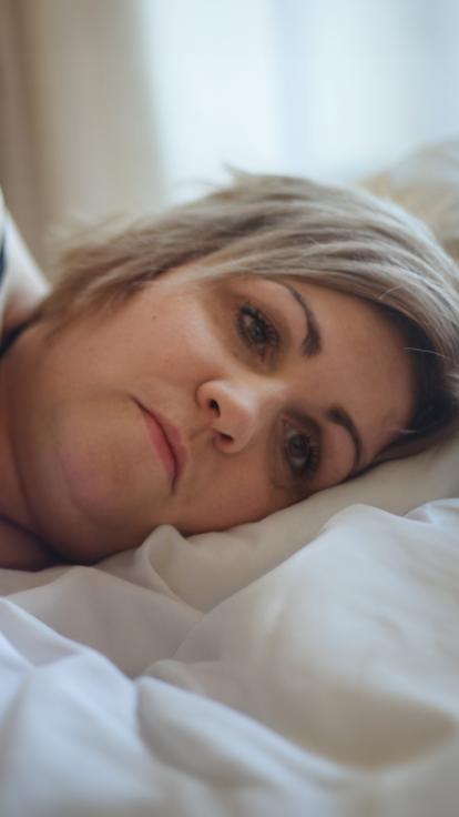 iemand staart voor zich uit in bed