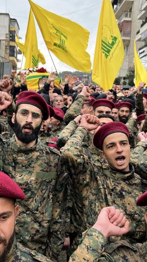 Hezbollah soldaten steken een vuist in de lucht tijdens een uitvaart