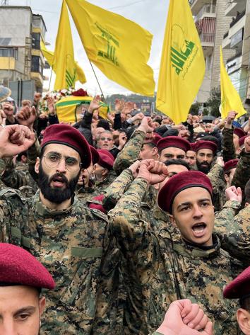 Hezbollah soldaten steken een vuist in de lucht tijdens een uitvaart