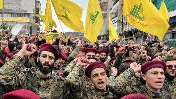 Hezbollah soldaten steken een vuist in de lucht tijdens een uitvaart