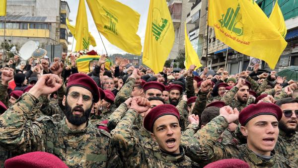 Hezbollah soldaten steken een vuist in de lucht tijdens een uitvaart