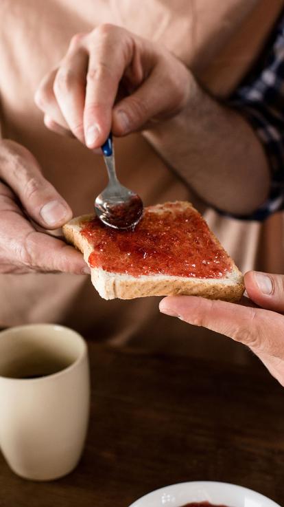 mensen smeren een boterham met jam