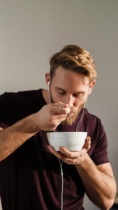 een persoon eet yoghurt uit een kom