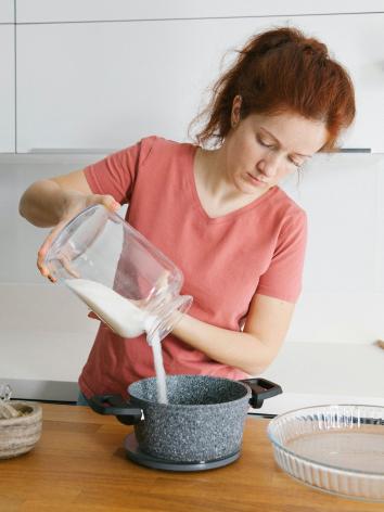 een vrouw doet suiker in een pan