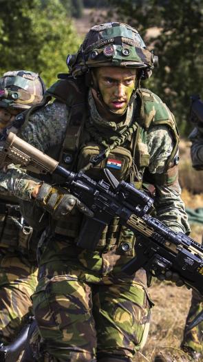 militairen van de landmacht lopen met geweren tijdens een militaire oefening