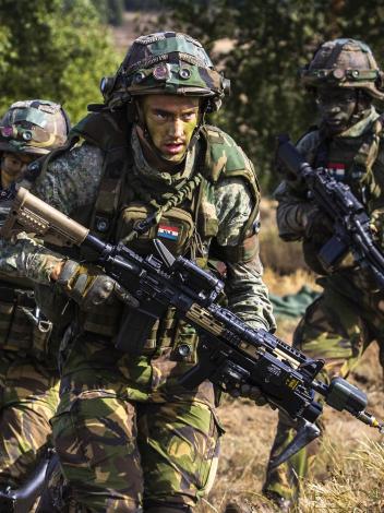militairen van de landmacht lopen met geweren tijdens een militaire oefening