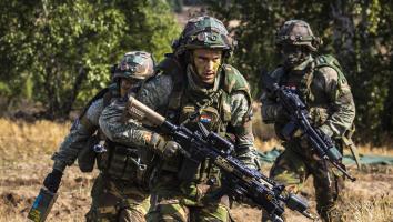 militairen van de landmacht lopen met geweren tijdens een militaire oefening