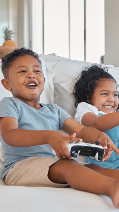 Kinderen zitten met game controllers op de bank 