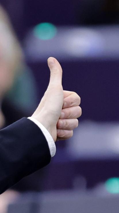 een Europarlementariër stemt voor een wet met een duim omhoog