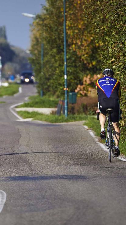 Landweggetje met daarop een wielrenner en de bodem is hobbelig door daling van de bodem.