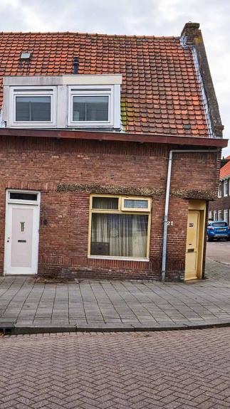 Hoekwoning waarbij de rechterzijde naar beneden is gezakt. De dakgoot is scheef.