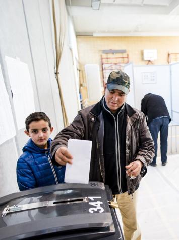 een burger aan het stemmen in een stemhokje