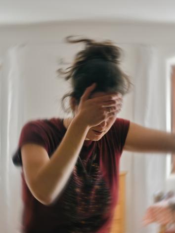 vrouw met hand op haar voorhoofd met 'draaiende' effecten eromheen