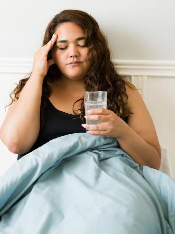 iemand ligt in bed met een kater