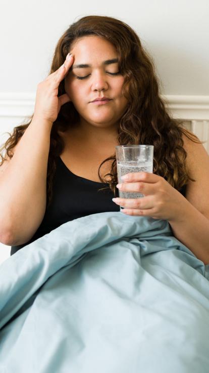 iemand ligt in bed met een kater