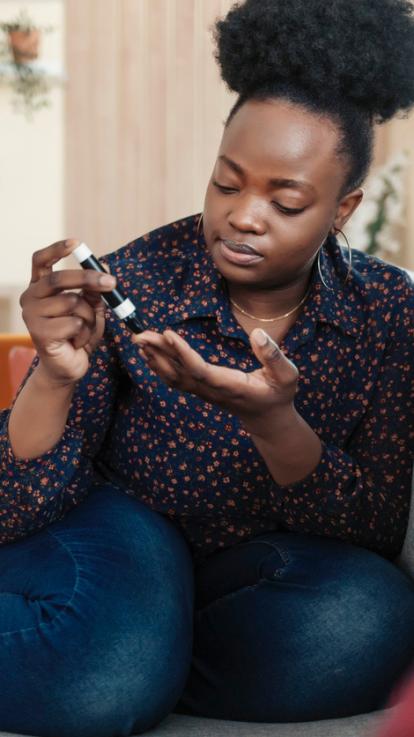 een vrouw prikt in haar vinger om haar bloedsuiker te meten