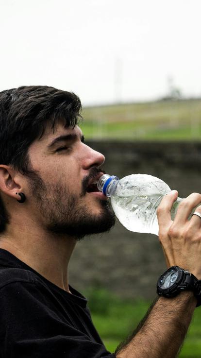iemand drinkt uit een fles water