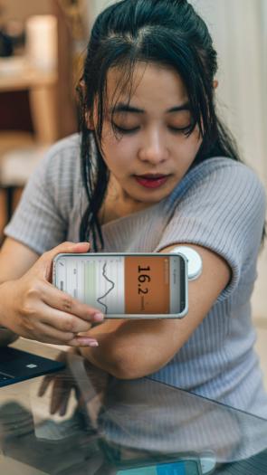 iemand checkt haar bloedglucose met een sensor