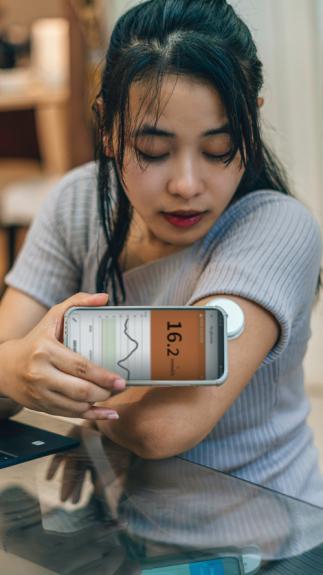 iemand checkt haar bloedglucose met een sensor