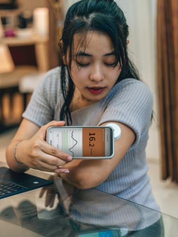 iemand checkt haar bloedglucose met een sensor