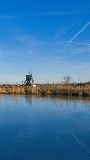 blauwe lucht boven het water en een molen