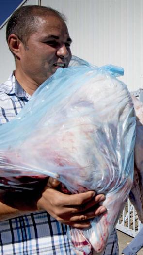 Tijdens het Offerfeest houdt een man een zak met vlees vast