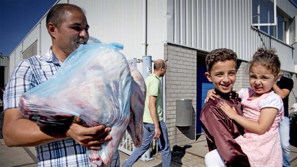 Tijdens het Offerfeest houdt een man een zak met vlees vast