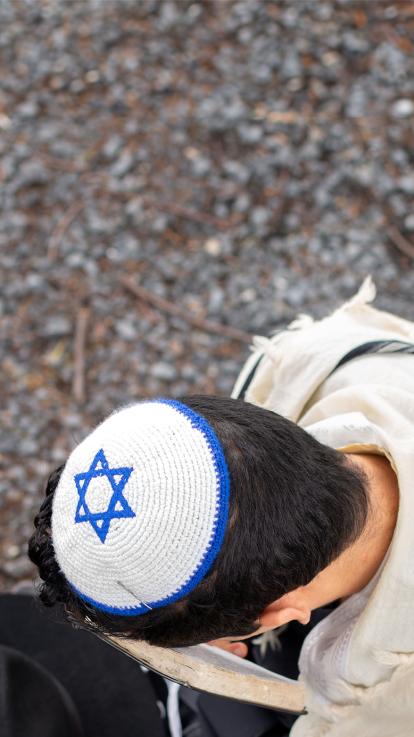 een man met een keppeltje met de Israëlische vlag aan het bidden