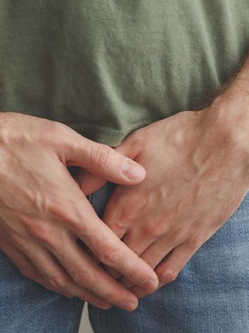 man houdt handen voor kruis