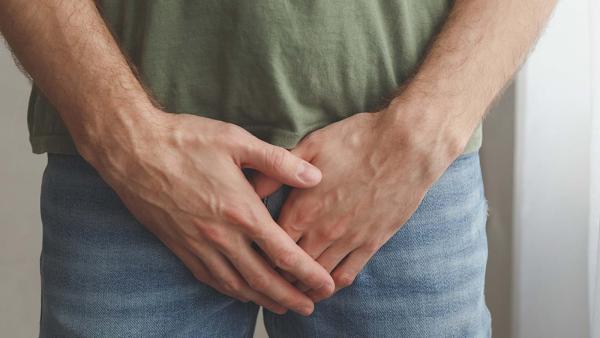 man houdt handen voor kruis