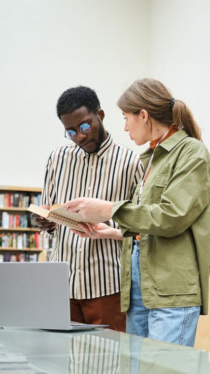 Twee mensen kijken in een boekenkast