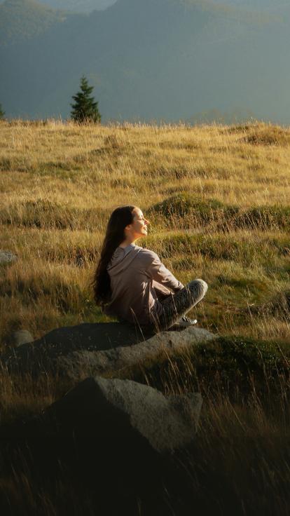 Meisje zit in de natuur en lacht