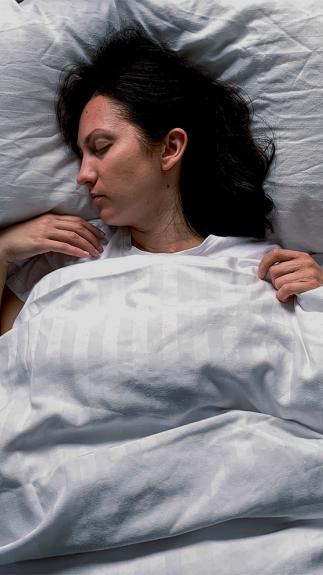 Een vrouw ligt in bed te slapen