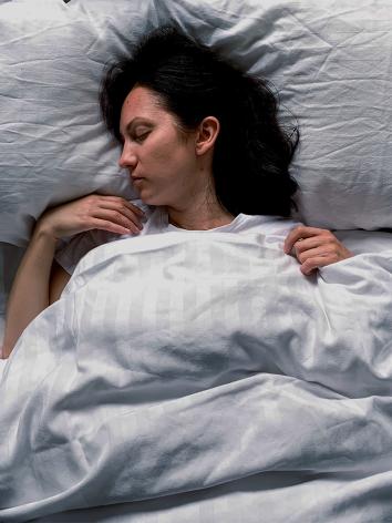 Een vrouw ligt in bed te slapen