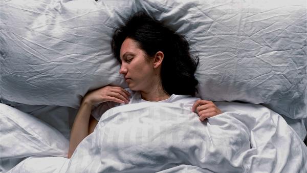 Een vrouw ligt in bed te slapen