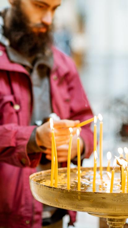 Een man steekt een kaars aan 