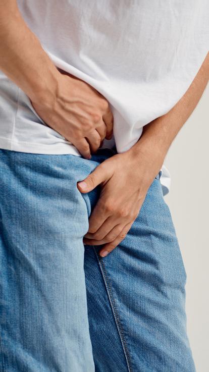 Man krabt aan zijn kruis en bukt voorover