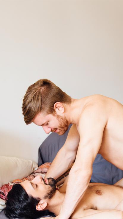 Een koppel lacht naar elkaar terwijl ze intiem zijn in bed