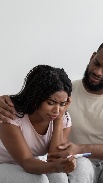 Koppel kijkt verdrietig naar zwangerschapstest