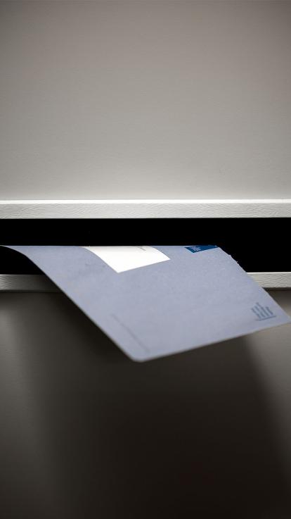 Er valt een blauwe envelop van de belastingdienst door de brievenbus