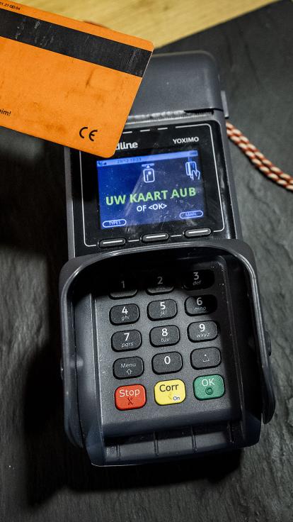 iemand legt pinpas op pinautomaat